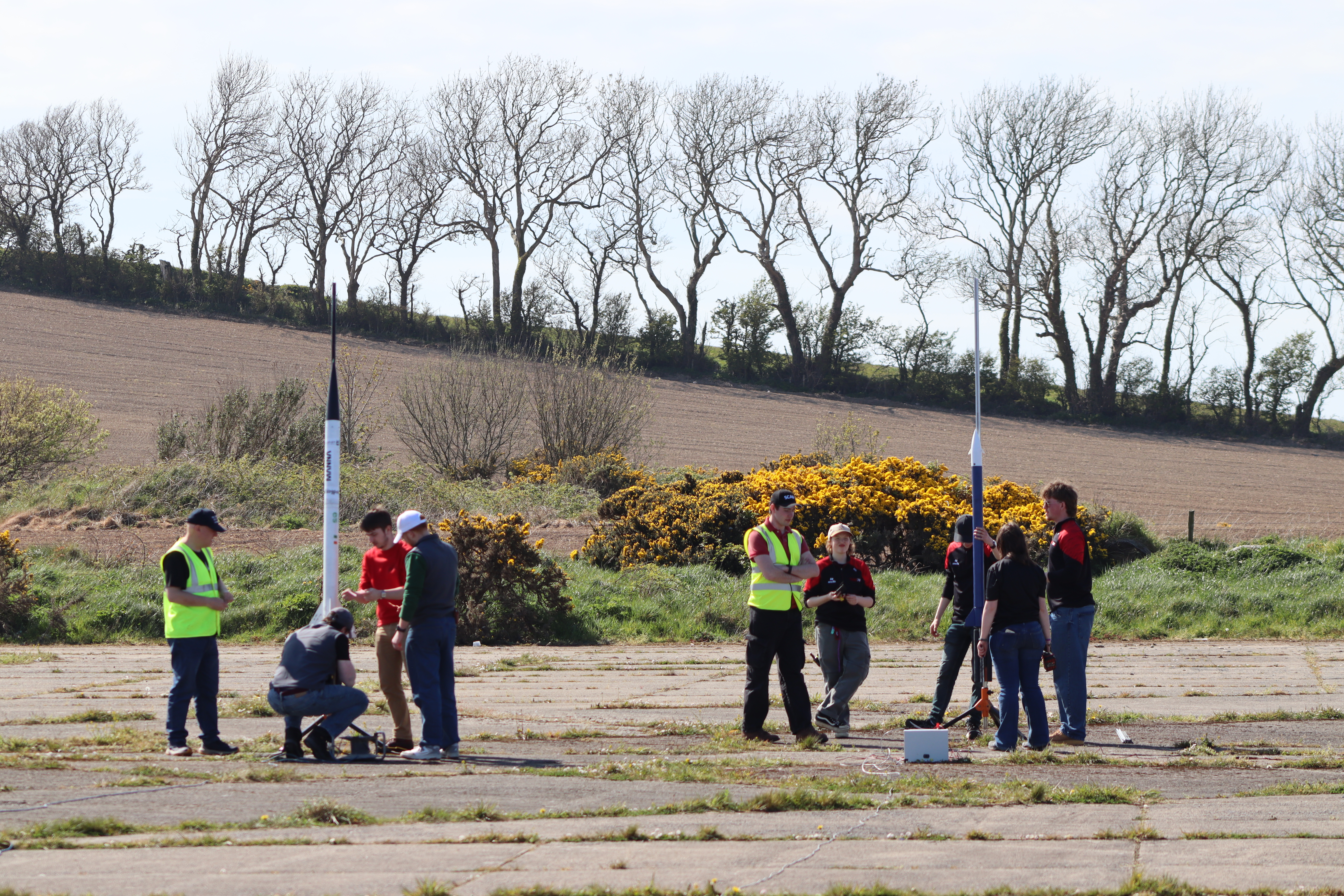 Group of people cheering holding model rockets from Ulster Rocketry launch in August